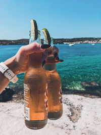 Cropped hand holding beers with lime