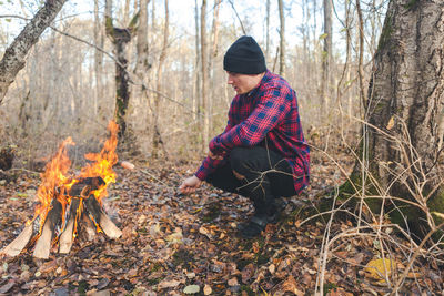 Man roasting food in campfire at forest