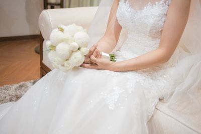 Midsection of woman holding bouquet