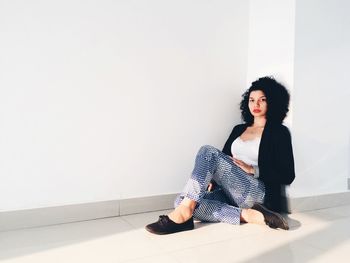 Young woman sitting on wall