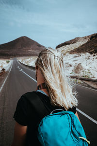 Woman traveler goes on desolate straight road over a surreal landscape. sao vicente cape verde