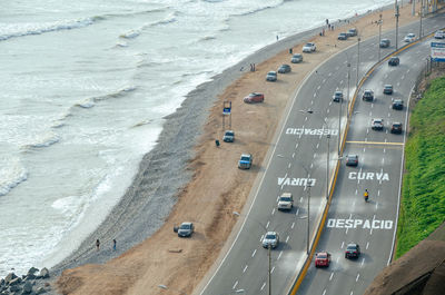 High angle view of cars on road by sea