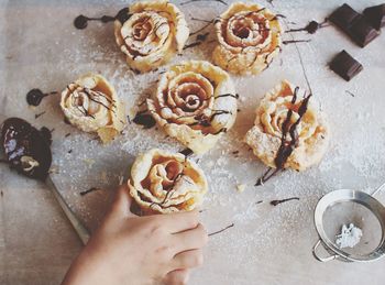 Cropped hand having sweet food on table