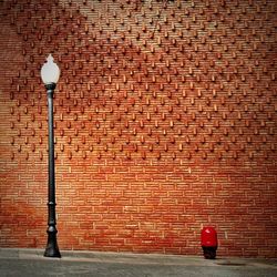 Light bulb against brick wall