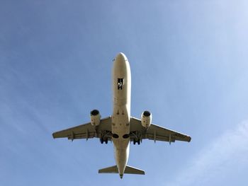 Low angle view of airplane flying against sky