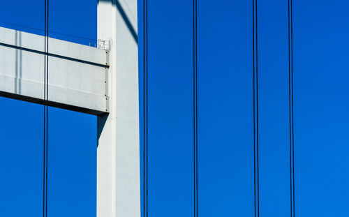 Abstract detail of the supporting structure of a bridge with piers and steel cables.