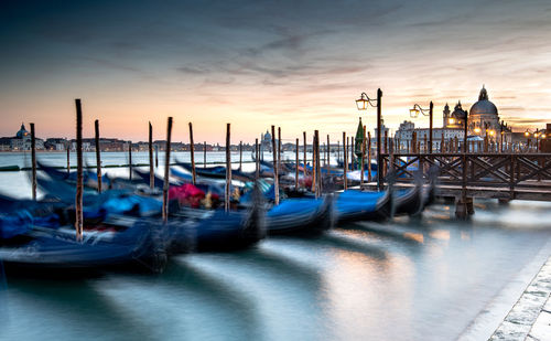 Boats moored in canal at sunset in venice, italy
