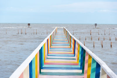 Multi colored pier over sea against sky