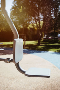 Close-up of swimming pool against trees on sunny day