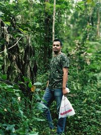 Portrait of young man standing in forest