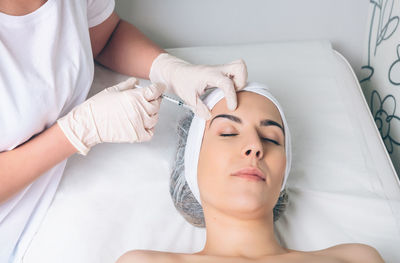 Midsection of woman lying on bed