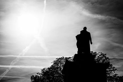 Low angle view of silhouette statue against sky