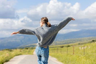 Rear view of woman standing on field