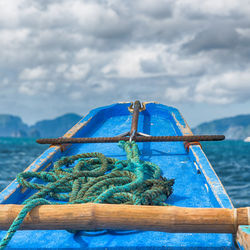 Close-up of rope tied on wooden post against sky