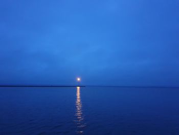 Scenic view of sea against blue sky at night