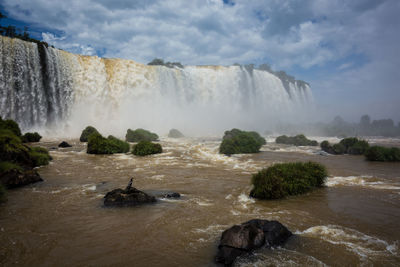 Scenic view of waterfall against sky