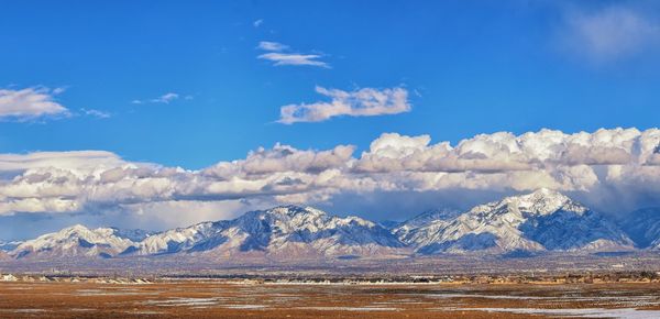 Scenic view of snowcapped mountains against blue sky