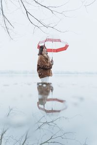 Multiple image of woman holding umbrella on snow covered field