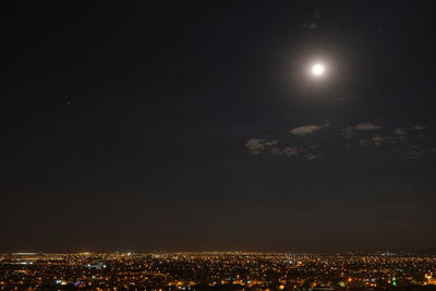 Illuminated cityscape against sky at night