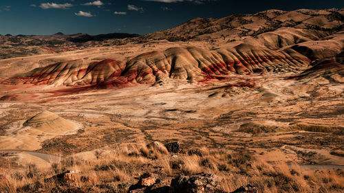 The painted hills in oregon. pretty unique and colorful mountain with red stripes on it.