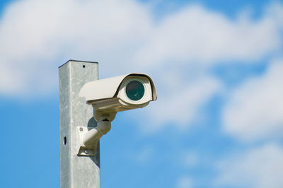 Low angle view of coin-operated binoculars against sky