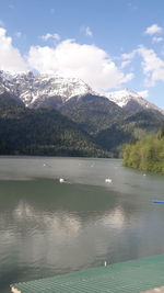 Scenic view of lake by mountains against sky