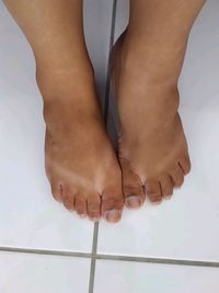 Low section of woman standing on tiled floor