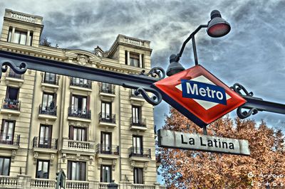 Low angle view of road sign against cloudy sky