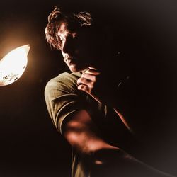 Side view of young man looking at camera