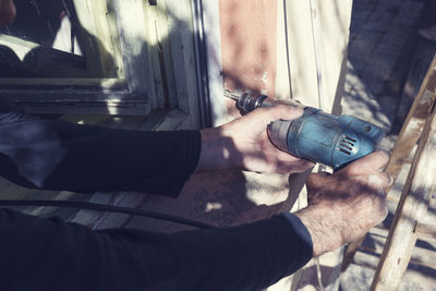 Cropped image of carpenter drilling wood