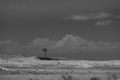 Scenic view of field against sky with windmill