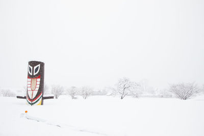 Bicycle on snow covered field against sky