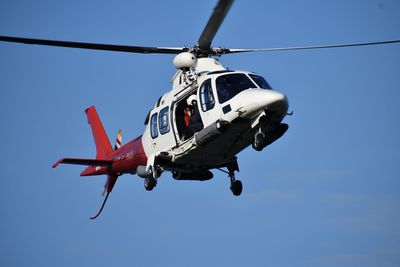 Low angle view of airplane flying against clear blue sky