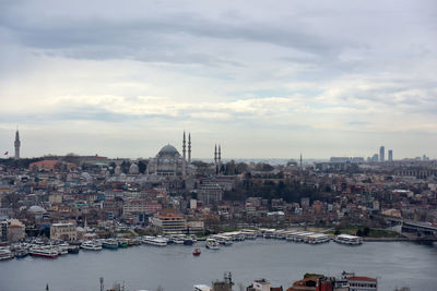 Buildings in city against cloudy sky