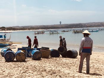 Rear view of people working on beach