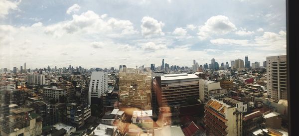 Cityscape against cloudy sky
