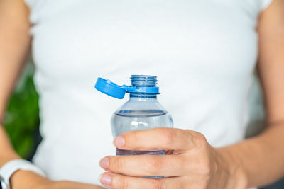 Midsection of man holding bottle