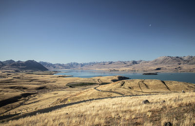 Scenic view of landscape and mountains against clear blue sky