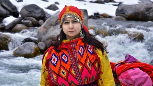 Beautiful girl in traditional wear in snow fall in manali / india