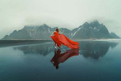 Woman in waved red dress on reynisfjara beach scenic photography