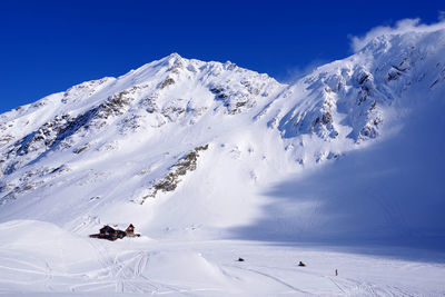 Scenic view of snowcapped mountain against blue sky