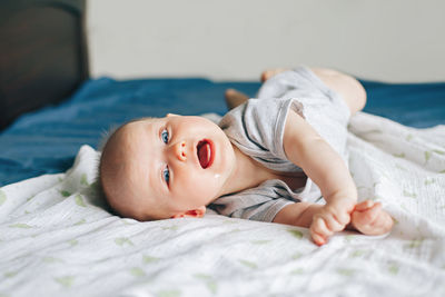 Portrait of cute baby lying on bed