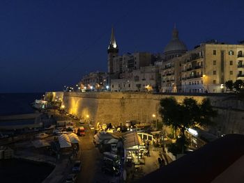 High angle view of illuminated buildings against clear sky at night