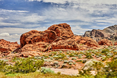 Rock formations on mountain against cloudy sky