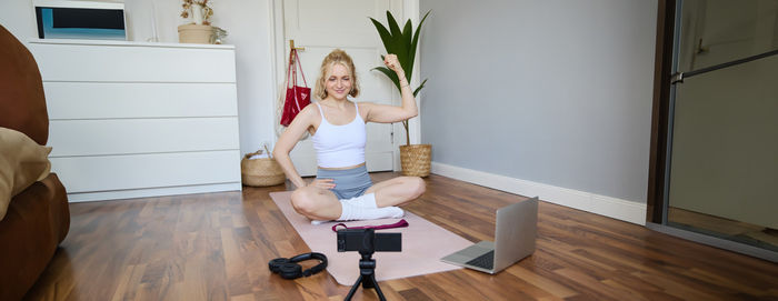 Full length of woman sitting on floor at home