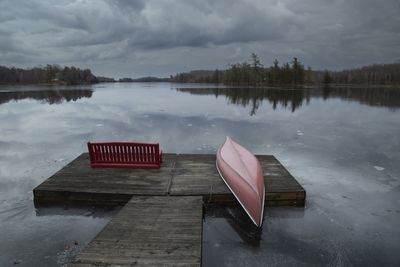 Storm clouds on the lake with a red canoe