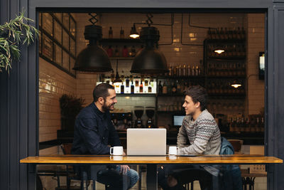 Man working on table in cafe