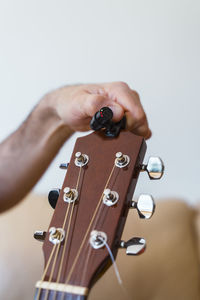 Cropped image of person repairing guitar