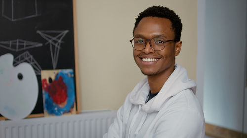 Smiling man wearing eyeglasses in classroom