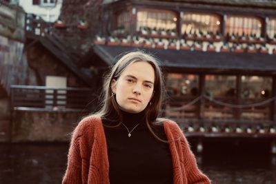 Portrait of young woman standing in city